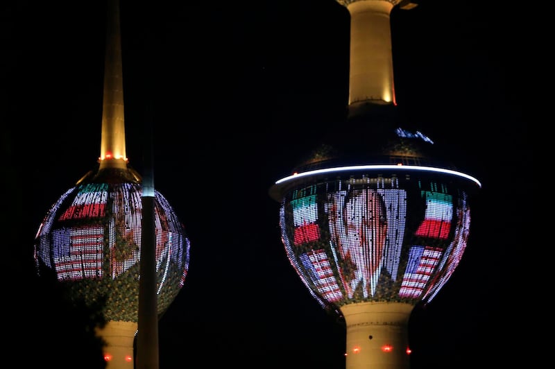 Kuwait's Towers in Kuwait City are illuminated in the colours of the American flag and a portrait of former US president George H.W. Bush on December 1, 2018, in tribute to the former US president. Bush, who guided America through the end of the Cold War and launched the international campaign to drive Iraqi strongman Saddam Hussein's forces from Kuwait, died Friday at his home in Houston. He was 94. / AFP / Yasser Al-Zayyat
