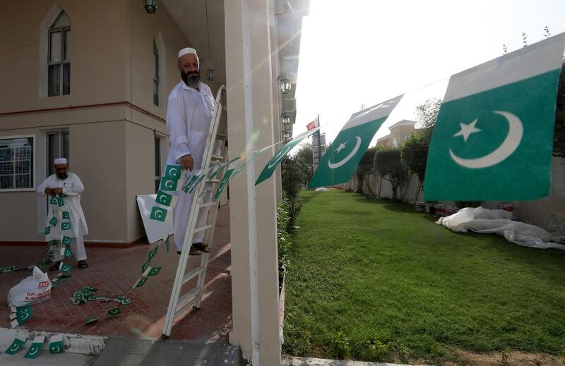 Mohammed Anwar, right, and Hafiz Imam Uddin, members of Pakistan Association Dubai, decorate the organisation’s premises with buntings ahead of the 67th anniversary of Pakistan’s Independence Day, which is celebrated on Thursday. Ravindranath K / The National  
