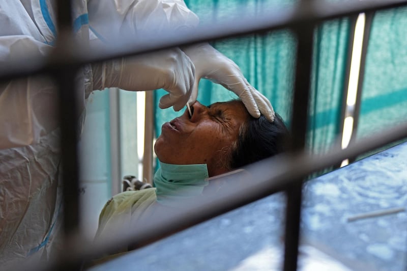 A health worker collects a nasal swab sample from a woman in Amritsar. AFP