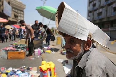 An Iraqi street vendor protects his head from the sun by using a piece of cardboard as a hat during a heat wave in the capital Baghdad on June 14, 2019. AFP