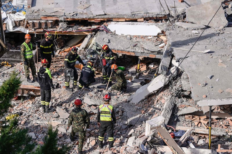 Italian search and rescue workers look for survivors stuck under the rubble of a collapsed building in the town of Durres, western Albania on November 27, 2019, after an earthquake hit Albania. Albania was in national mourning on November 27 as emergency workers continued to pull bodies from the ruins of buildings gutted by a violent earthquake, with nearly 30 dead found so far and more than 40 rescued alive. Tirana declared a state of emergency in the areas hardest-hit by the November 26 pre-dawn earthquake: the coastal city of Durres and the town of Thumane, where victims were trapped by toppled buildings. / AFP / Armend NIMANI
