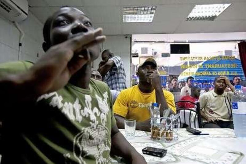 Football fans watch the match between Cameroon and Japan at the Sahar African Restaurant in Deira yesterday.