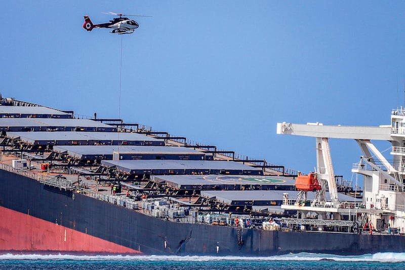 A helicopter hovers over the vessel MV Wakashio in southeast Mauritius.  AFP