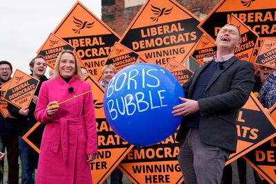 Newly elected Liberal Democrat MP Helen Morgan, bursts the "Boris' bubble" held by colleague Tim Farron, as she celebrates in Oswestry, Shropshire, following her victory in the North Shropshire by-election, December 17. PA via AP