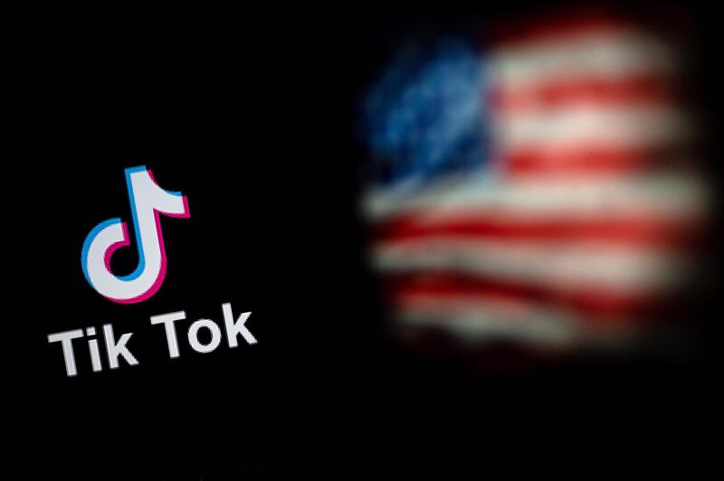This photo illustration taken on September 14, 2020 shows the logo of the social network application TikTok (L) and a US flag (R) shown on the screens of two laptops in Beijing. US tech giant Microsoft said on September 13 its offer to buy TikTok was rejected, leaving Oracle as the sole remaining bidder ahead of the imminent deadline for the Chinese-owned video app to sell or shut down its US operations. / AFP / NICOLAS ASFOURI
