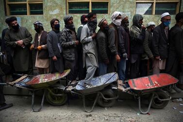 Afghan labourers queue to receive free wheat in Kabul. AP Photo