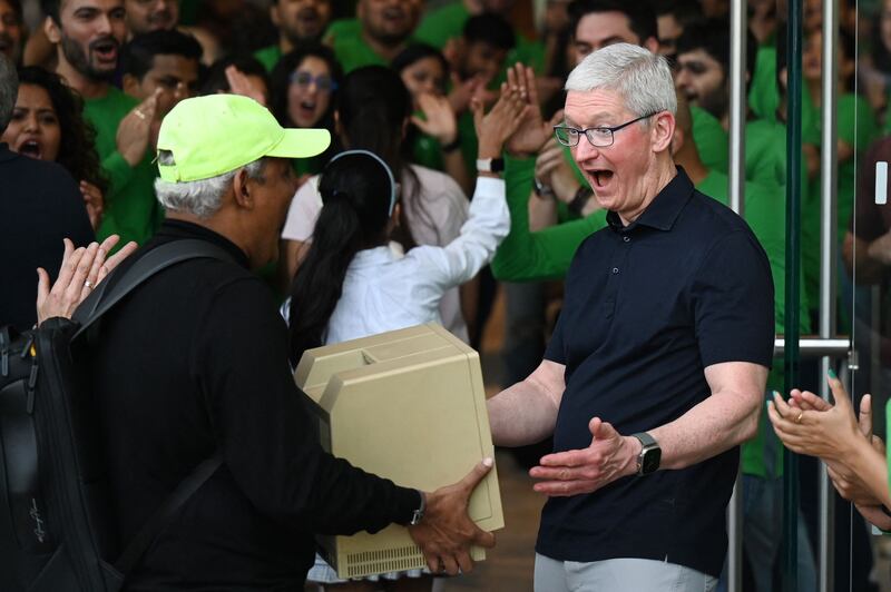 Chief executive Tim Cook is blown away as he is shown an original Macintosh SE computer at the opening of Mumbai's first Apple Store in April 2023. AFP
