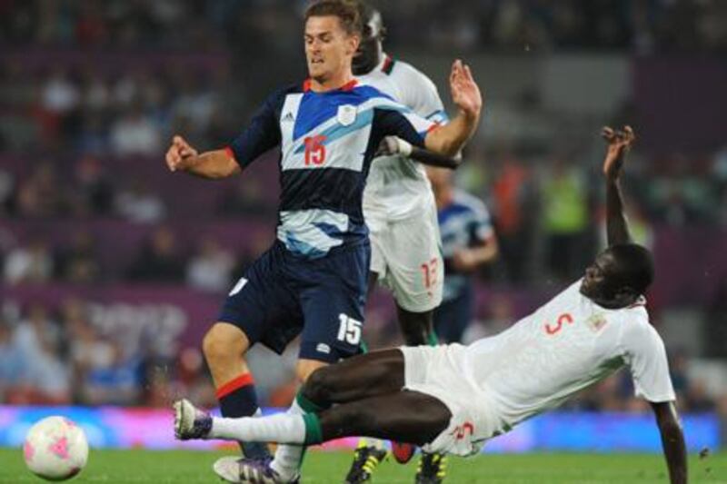 epa03319048 Great Britain's Aaron Ramsey (L) is tackled by Senegal's Papa Gueye during the match between Great Britain and Senegal in the London 2012 Olympic Games Soccer tournament, Manchester, Britain, 26 July 2012.  EPA/Robin Parker