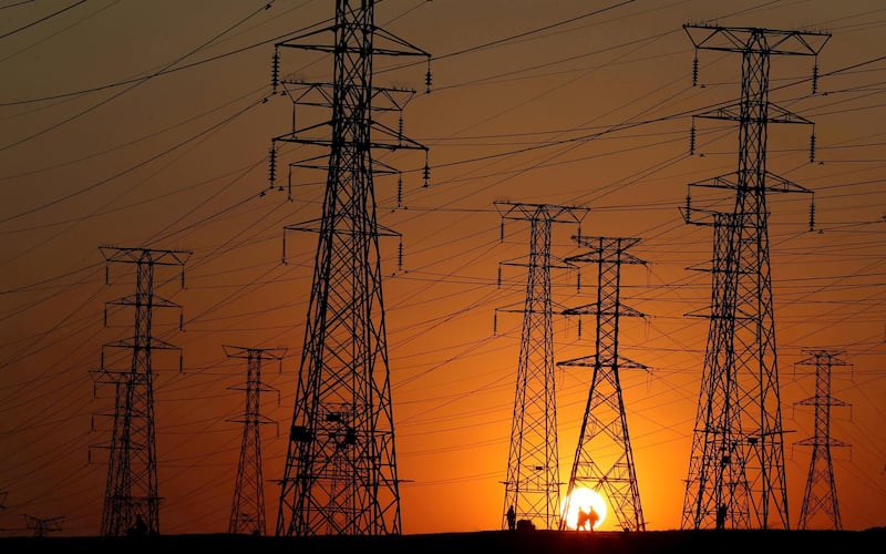 FILE PHOTO: Locals walk past Eskom's electricity pylons as they return from work in Orlando, Soweto township, South Africa, July 20, 2020. Picture taken July 20, 2020. REUTERS/Siphiwe Sibeko/File Photo