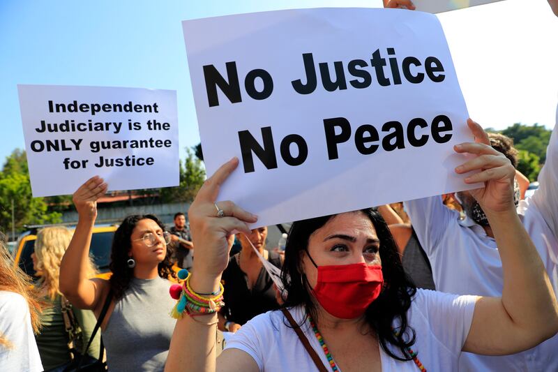 Supporters of families whose relative were killed in last year's explosion at Beirut's seaport, hold placards during a protest in support of legal action near the blast scene, in Beirut, on July 12. AP