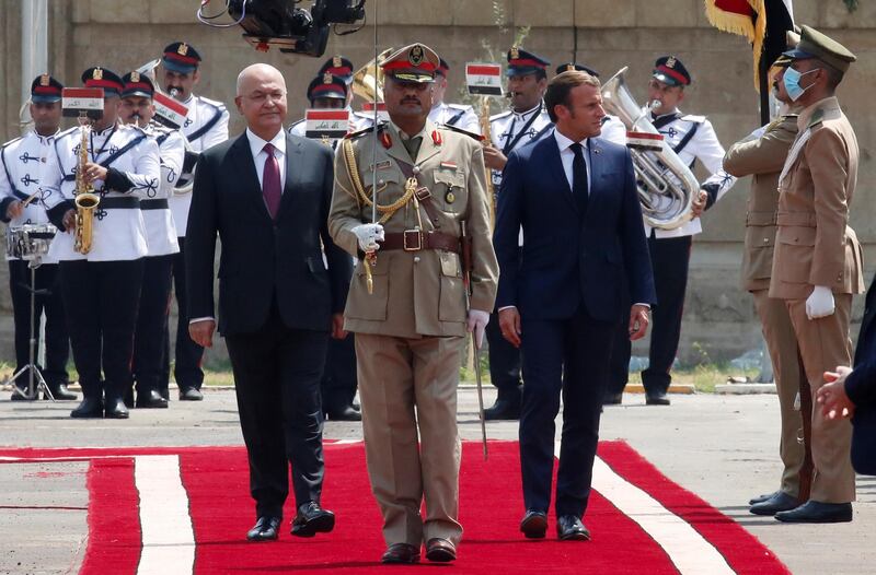 Iraqi President Barham Salih and French President Emmanuel Macron, right, review the guard of honour as they arrive at the Salam Palace in Baghdad.  AP