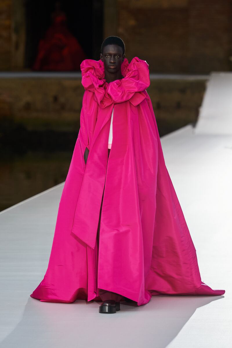 At Valentino autumn 2021 haute couture, even men's wear arrives with a raspberry cape, gathered at the neck