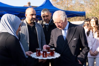King Charles is served tea during a visit in London on Tuesday to meet members of the Turkish diaspora collecting aid for people affected by the earthquake in Turkey and Syria. AFP