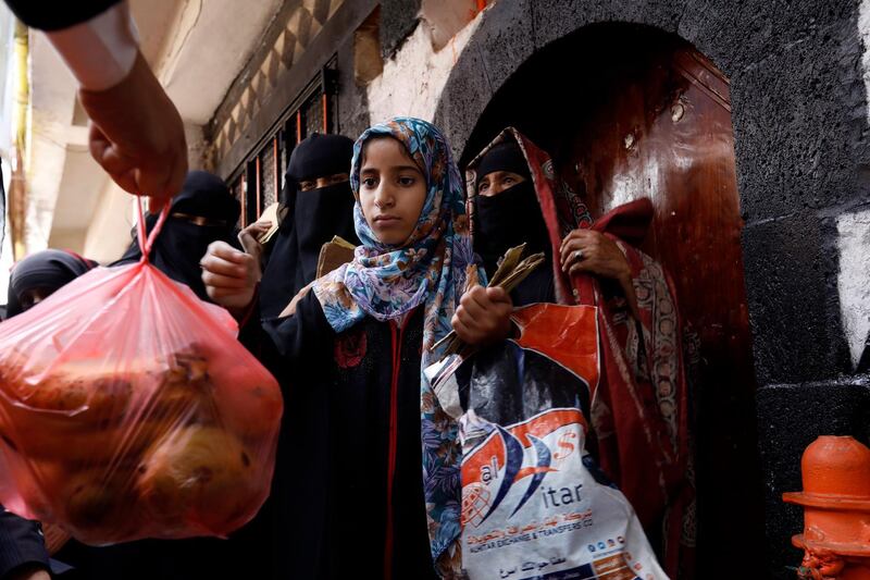 A Yemeni girl is given free food by a charity group in the city. EPA