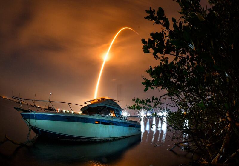 A long-exposure shows a streak across the sky above an abandoned boat during the launch of a Falcon 9 rocket and 60 Starlink satellites. The launch was from Cape Canaveral Space Force Station. Florida Today via AP