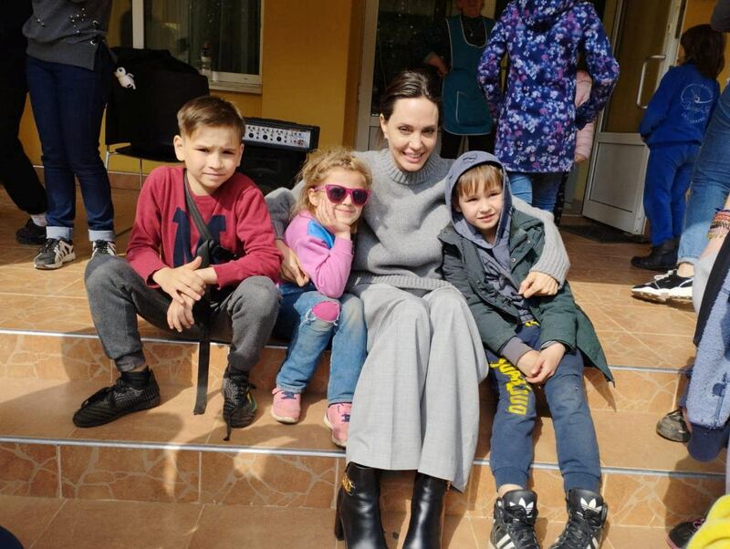 Jolie poses for a picture with Ukrainian children. Reuters