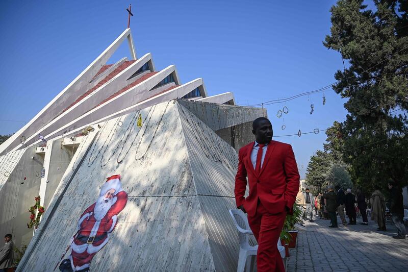 A man walks past a Santa Claus image on the side of Fatima Church after Christmas Day prayers in Islamabad, Pakistan. AFP