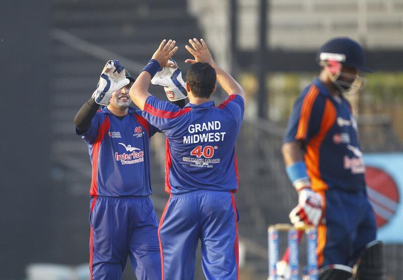 Kamran Akmal celebrates with a teammate following a wicket on Thursday in the semi-finals of the Bukhatir Cricket League in Sharjah. Jeffrey E Biteng / The National / June 26, 2014