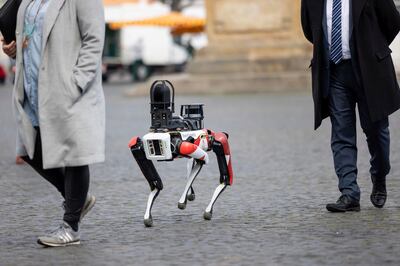 Spot, a robot with dog-like movements, walks across the Domplatz square in Erfurt, Germany, Tuesday, April 20, 2021. The security service provider Ciborius, supplier of robotic security solutions with artificial intelligence, presented its artificial employee with high-resolution 360-degree all-round camera, ultra-bright LED light and a light detection system. (Michael Reichel/dpa via AP)