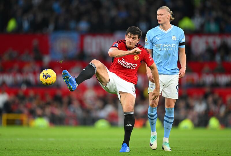 Harry Maguire of Manchester United attempts to pass the ball whilst under pressure from Erling Haaland. Getty