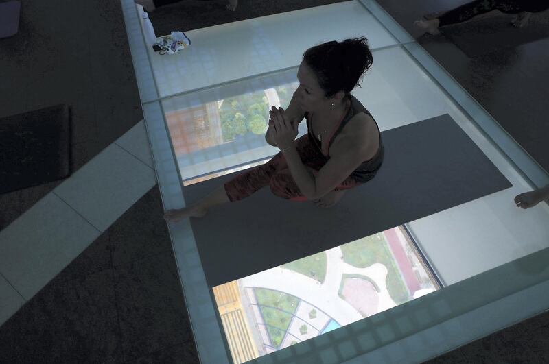DUBAI, UNITED ARAB EMIRATES , August 12 – 2020 :-  Participants during the Yoga Class taken by the Nitai Krishna on the glass bottomed part of the Dubai Frame in Dubai. Total 30 participants took part in the morning yoga, which started from 7:30 am to 8:30 am. This is a part of Dubai Summer Surprise.  (Pawan Singh / The National) For Arts & Culture/Online/Instagram. Story by Evelyn
