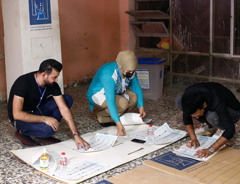 Election workers count ballots at a polling station in Baghdad at the end of voting in parliamentary elections. AP