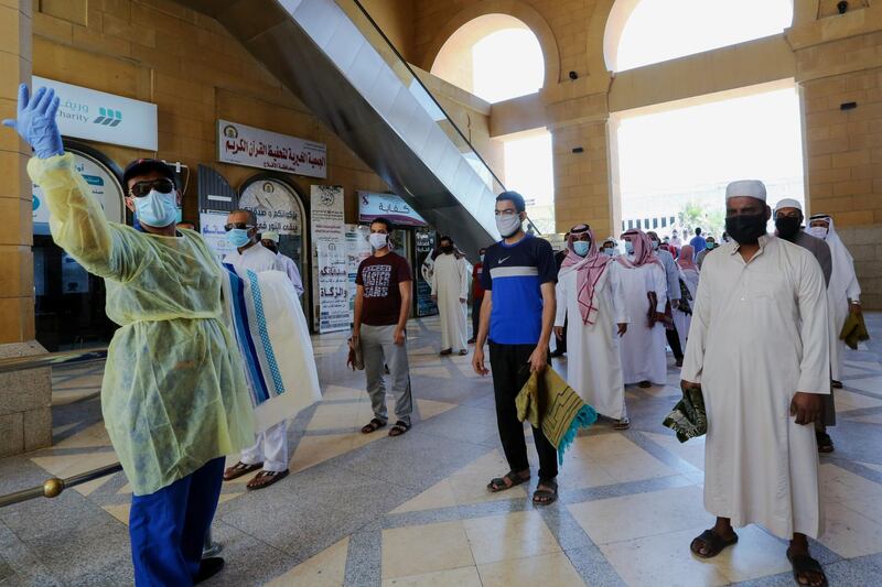 A security man checks the worshipers before they perform the Friday prayers inside the Al Rajhi Mosque while practising social distancing. Reuters