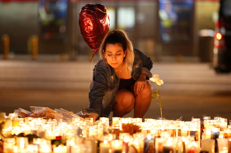 A woman lights candles at a vigil on the Las Vegas strip following a mass shooting at the Route 91 Harvest Country Music Festival in Las Vegas, Nevada, U.S., October 2, 2017. Picture taken October 2, 2017. REUTERS/Chris Wattie