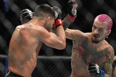 Jul 2, 2022; Las Vegas, Nevada, USA; Pedro Munhoz (red gloves) and Sean O'Malley (blue gloves) fight in a bout during UFC 276 at T-Mobile Arena.  Mandatory Credit: Stephen R.  Sylvanie-USA TODAY Sports