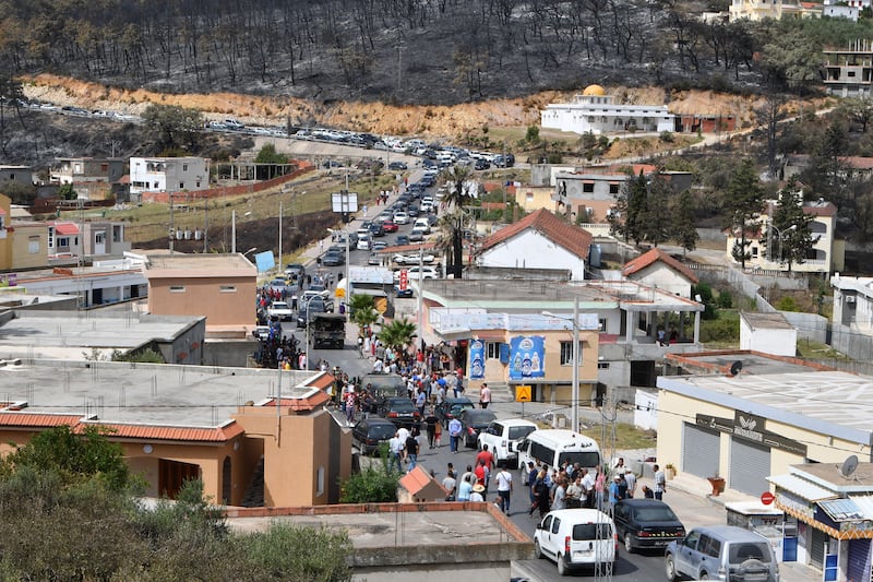 Residents block a street as they demand the restoration water supplies in Melloula, following recent heatwaves and a forest fire in the area.  AFP