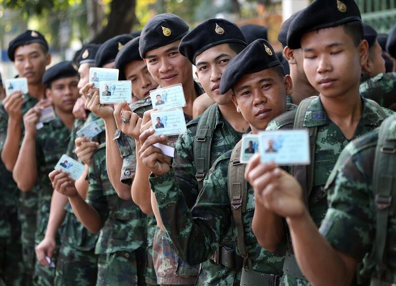Thai soldiers pose with their identity cards as they wait to vote. The army deployed 5,000 soldiers in Bangkok to boost security for Sunday's general election. AP Photo