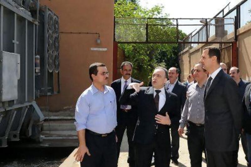 Syrian President Bashar Al Assad (right) with his minister of electricity, Imad Khamis, during a visit at Umawyeen electricity station to celebrate workers’ day.