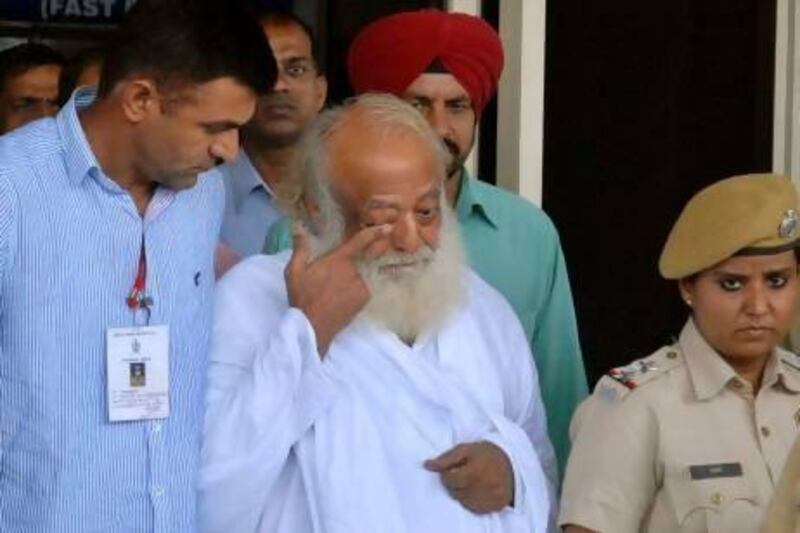 Controversial spiritual guru Asaram Bapu, in white, is brought for interrogation by police at the Jodhpur airport.