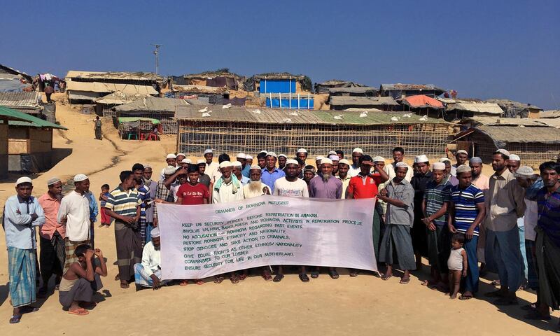 A group of Rohingya refugees hold up a  banner that show a list of demands before Bangladesh and Myanmar governments start the process of repatriation, at Kutupalong refugee camp, near Cox's Bazar, Bangladesh, Saturday, Jan. 20, 2018. Rohingya refugees are continuing to flee from Myanmar into Bangladesh, even after the two countries said they will begin repatriating members of the minority ethnic group next week, a Bangladesh official said Friday. Over 650,000 Rohingya Muslims poured into Bangladesh after Myanmar's military launched a brutal crackdown against them in August. (AP Photo/Rishabh R. Jain)