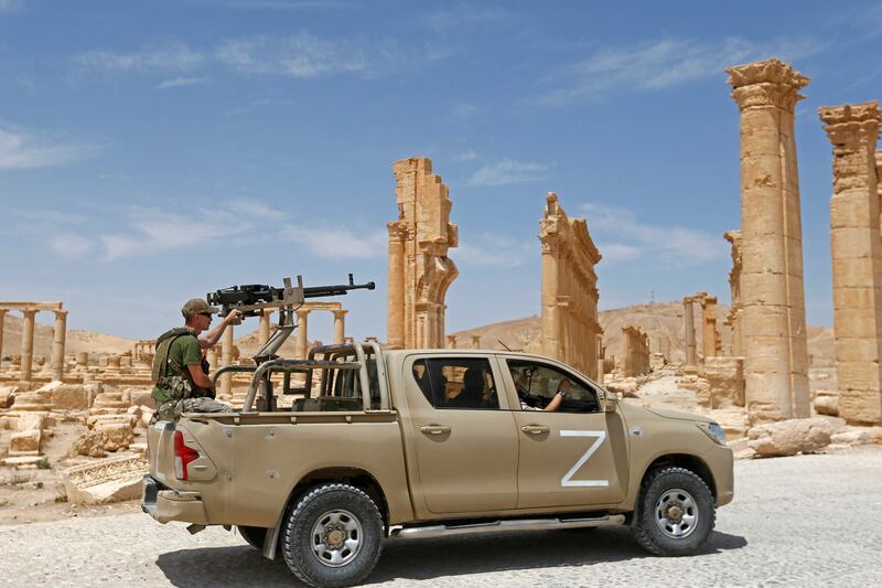 Russian forces ride past the Arch of Triumph, also known as the Monumental Arch, in the ancient Syrian city of Palmyra. AFP