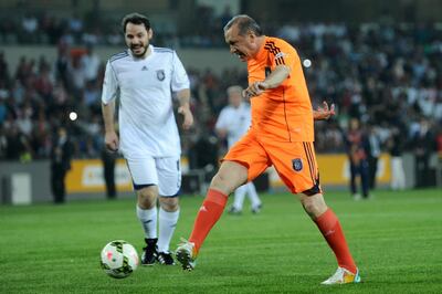 Turkish Prime Minister Recep Tayyip Erdogan (R) vies for the ball with Beraat Albayrak (R) during an exhibition match at the Basaksehir stadium on 26 July, 2014 in Istanbul.  AFP PHOTO / OZAN KOSE (Photo by OZAN KOSE / AFP)