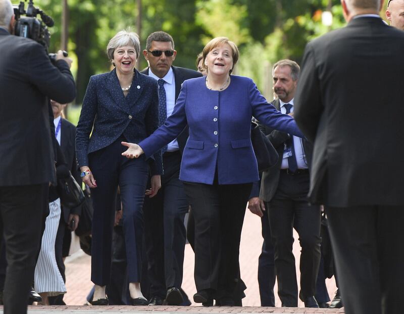 Germany's Chancellor Angela Merkel, centre, and British Prime Minister Theresa May arrive at an informal European Union summit with Western Balkans countries in Sofia, Bulgaria. Vasil Donev / EPA