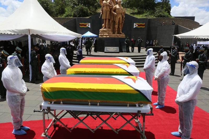 Pallbearers stand next to coffins of three top government officials at their burial at the National Heroes acre in Harare. Zimbabwe on Wednesday buried three top officials who succumbed to COVID-19, in a single ceremony at a shrine reserved almost exclusively for the ruling elite as a virulent second wave of the coronavirus takes a devastating toll on the country. AP