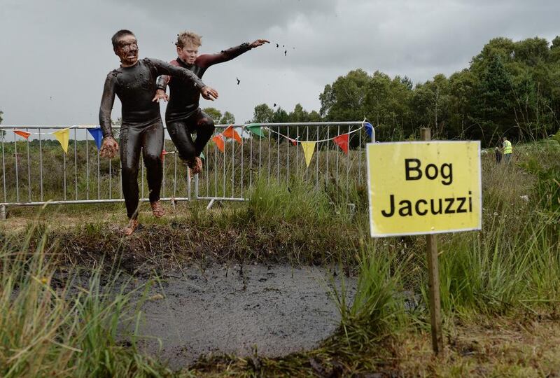 Patrick Colan-O'Leary, left, and Conor McCarthy, right, take a dip in the Bog Jacuzzi after competing in the Irish Bog Snorkelling championship on Sunday. Charles McQuillan / Getty Images  