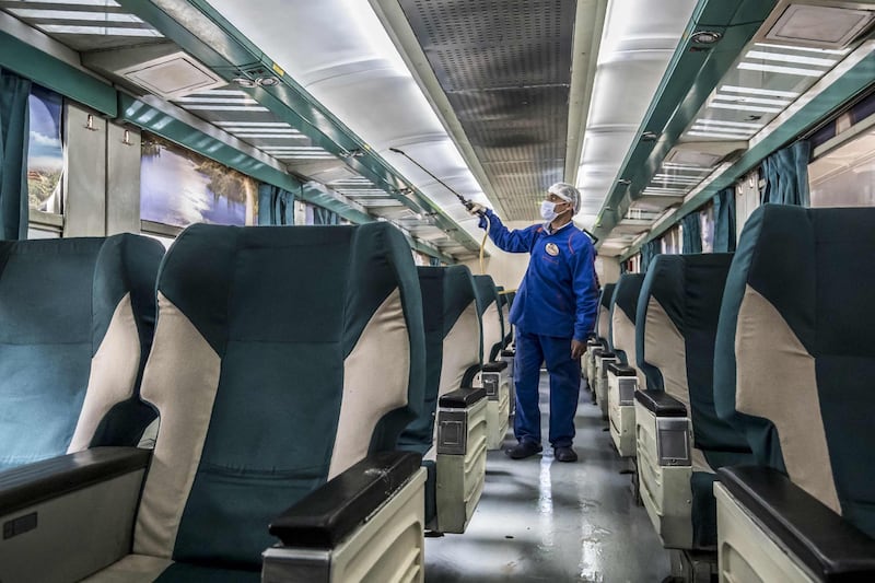 An Egyptian worker sprays disinfectant inside a train at Cairo's Ramses railway station. AFP