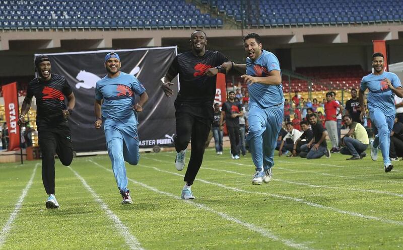 Yuvraj Singh, second right, jokingly tries to push Usain Bolt during a 100-metre friendly sprint in Bangalore on Tuesday. Aijaz Rahi / AP