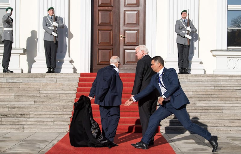 A bodyguard hastens to grab the coat that Tunisian President Beji Caid Essebsi takes off as he is welcomed by German President Frank-Walter Steinmeier before a meeting at Bellevue Castle in Berlin.   AFP