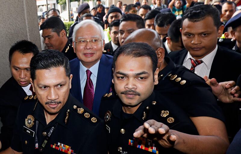 Najib Razak, Malaysia's former prime minister, center left, arrives at the Kuala Lumpur Courts Complex in Kuala Lumpur, Malaysia, on Wednesday, July 4, 2018. Najib has plead not guilty to charges of corruption and criminal breach of trust in connection with a multibillion-dollar scandal surrounding state fund 1MDB. Photographer: Samsul Said/Bloomberg