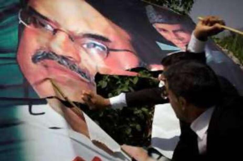 Pakistani lawyers tear down a poster of Benazir Bhutto's widower, Asif Ali Zardari, who will run for president in the Sept 6 election.