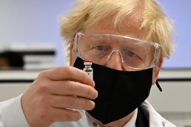 UK Prime Minister Boris Johnson looks at a vial of the AstraZeneca/University of Oxford vaccine against Covid-19. Reuters