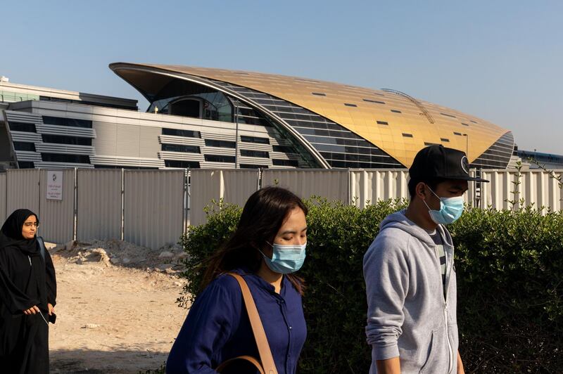 Commuters, wearing protective face masks, walk after exiting a metro station in downtown Dubai, United Arab Emirates, on Thursday, March 5, 2020. The Middle East’s travel and business hub has called on citizens and residents to avoid travel due to the coronavirus risk. Photographer: Christopher Pike/Bloomberg