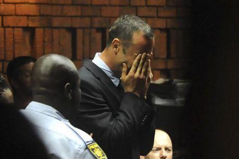 Oscar Pistorius weeps as he appears in a Pretoria court after spending the night in police custody. His bail hearing was postponed until Tuesday.