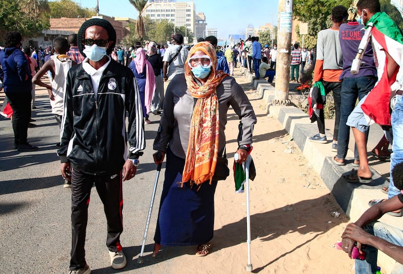 A woman using crutches attends the protests. AFP
