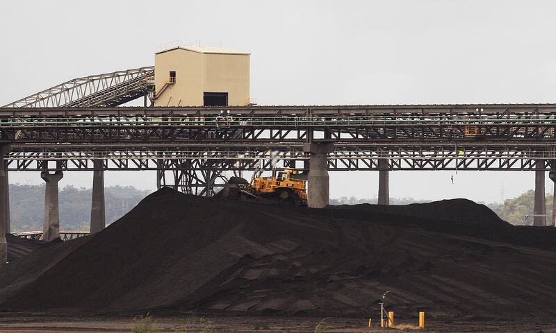FILE PHOTO: FILE PHOTO: A tractor makes its way over a pile of coal at a coal port in Gladstone, Queensland January 7, 2011. REUTERS/Daniel Munoz/File Photo