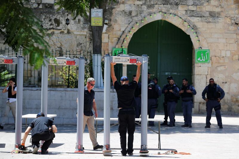 Men install metal detectors at an entrance to the compound known to Muslims as Noble Sanctuary and to Jews as Temple Mount, in Jerusalem's Old City July 16, 2017. Ammar Awad / Reuters